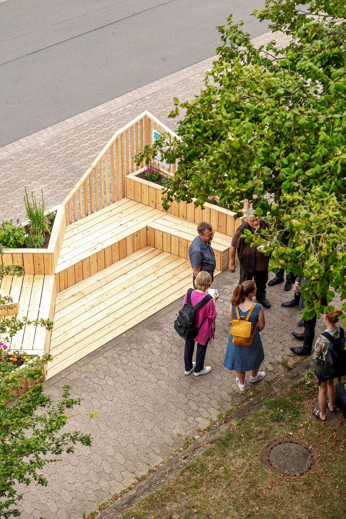 Luftaufnahme von einer Menschengruppe vor einem Parklet